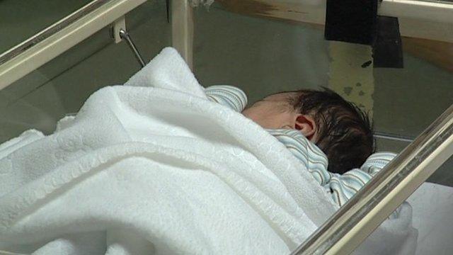 Baby in hospital cot