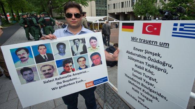 Protester outside court with photos of murder victims, 14 May 13