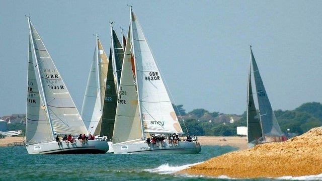 The class three yachts tack away from the beach in the eastern Solent off Alverstoke