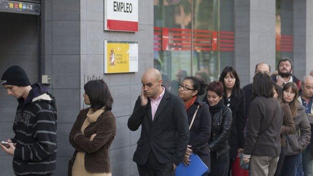 People queue outside a government unemployment office in Madrid, Spain