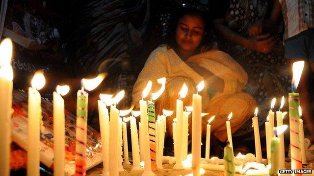 Bangladeshi garment workers and relatives of victims of the Rana Plaza building collapse hold candles during a memorial