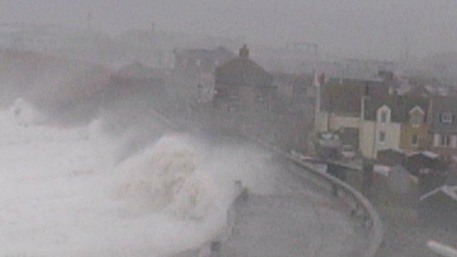 Waves crashing over the sea wall at Chiswell, overlooking Chesil Cove, Portland, Dorset