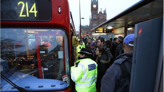 Commuters waiting at a bus stop at King's Cross station