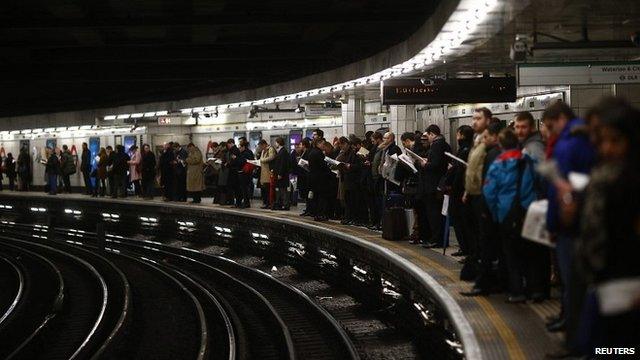 Passengers at a Tube station in the evening