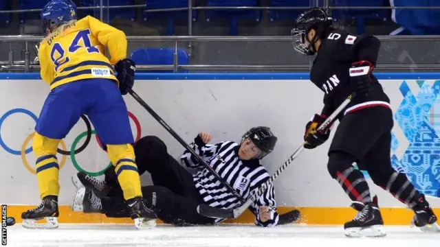 A linesman falls on the ice