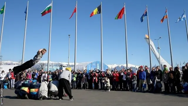 A group of performers entertain spectators during a quiet moment in the Olympic Park