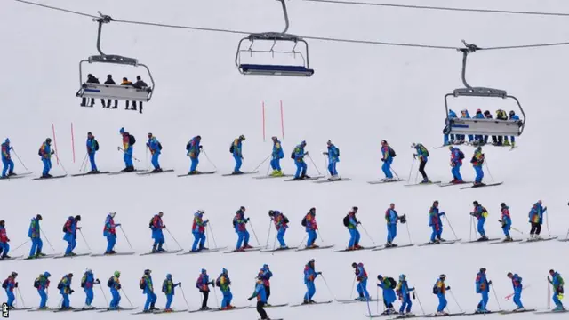 Volunteers flatten the snow prior to the start of the Men's Alpine Skiing Super Combined Slalom at the Rosa Khutor Alpine Centre