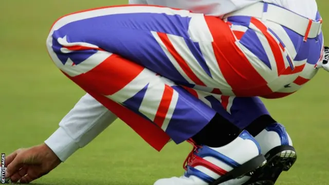 Ian Poulter of England marks his ball wearing his Union Jack trousers during the first round of the 133rd Open Championship at the Royal Troon Golf Club on July 15, 2004.