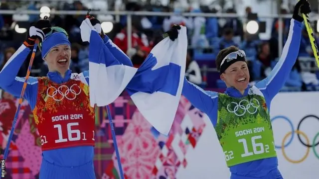 Finland's Iivo Niskanen (L) holds a national flag with teammate Sami Jauhojaervi