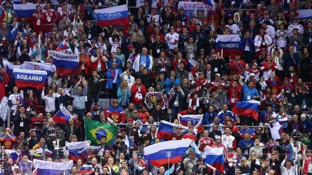 Fans hold up Russian flags