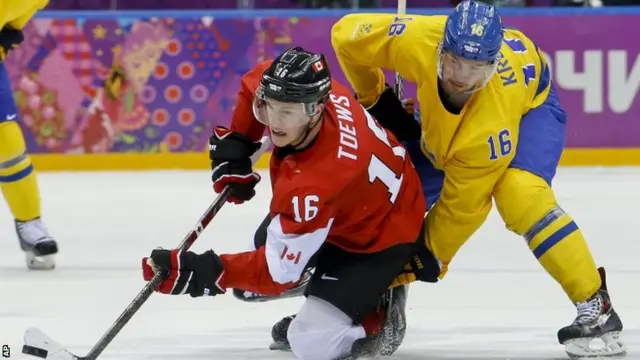 Canada's Jonathan Toews gets the puck away ahead of Marcus Kruger of Sweden