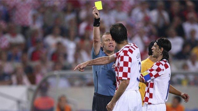 Graham Poll gives Croatia's Josip Simunic a yellow card