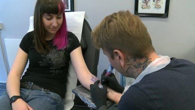 Woman having a tattoo done