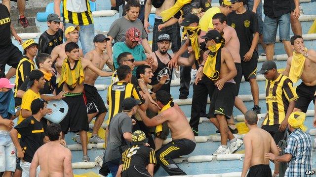 Fans of Uruguay's Penarol clash during the Uruguayan first division football derby against Nacional, at the Centenario stadium in Montevideo on November 24, 2013.