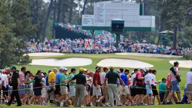 Patrons cross the seventh fairway