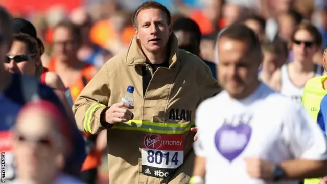 A competitor dressed as a fireman runs during the London Marathon