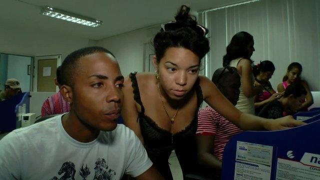 A man and woman use a computer at an internet access centre in Cuba