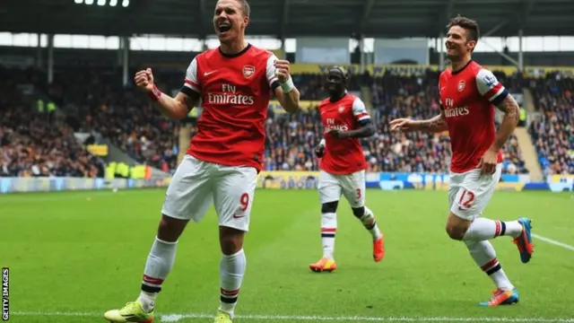 Lukas Podolski (left) celebrates scoring for Arsenal