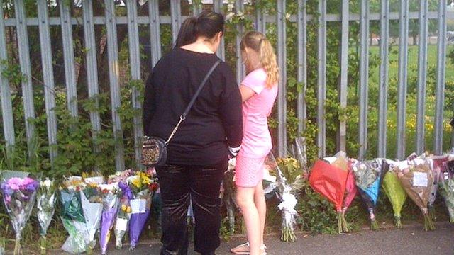 People looking at floral tributes