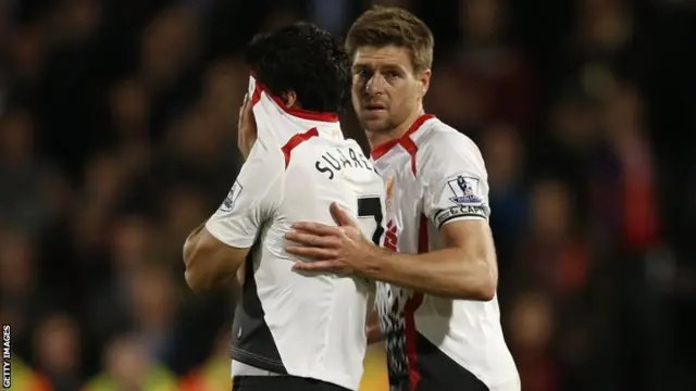 English midfielder Steven Gerrard shepherds Liverpool's Uruguayan striker Luis Suarez