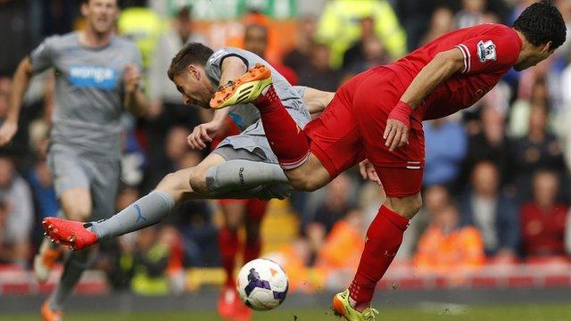 Paul Dummett (left) tackles Liverpool's Luis Suarez