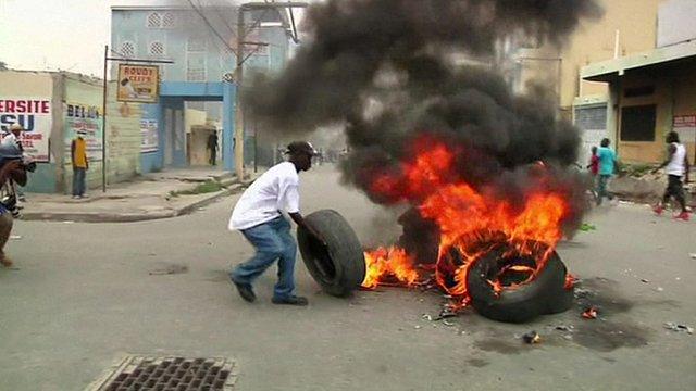 A protester burns a tyre on the streets of Port-au-Prince