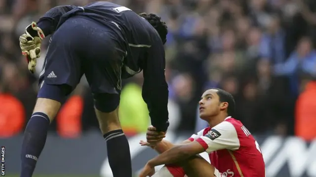 Arsenal forward Theo Walcott is consoled by Chelsea goalkeeper Petr Cech