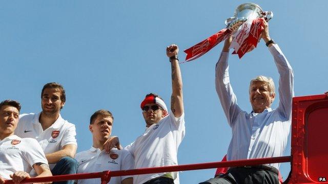 Arsene Wenger holding the trophy