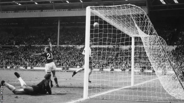 Geoff Hurst (not seen) scores the controversial third goal in the World Cup Final