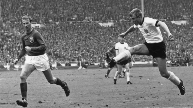 Siegfried Held shoots for West Germany as Jack Charlton looks on