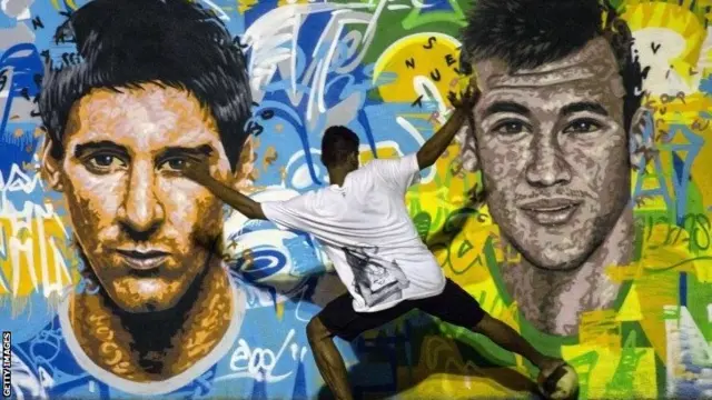 Brazil fan in front of Messi & Neymar mural