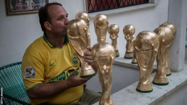 Brazil fans kisses a replica World Cup trophy