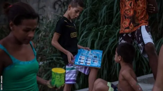 Boy shows off sticker collection in Santa Marta favela