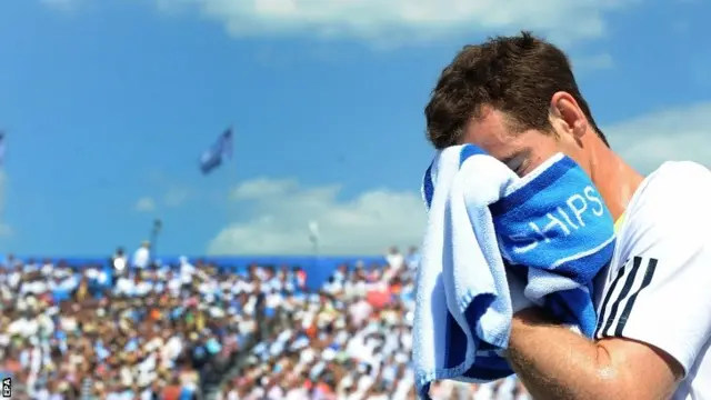 Andy Murray wipes his face with a towel