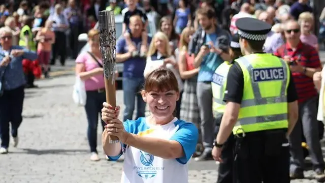 Lorraine Kelly holding Queen's baton