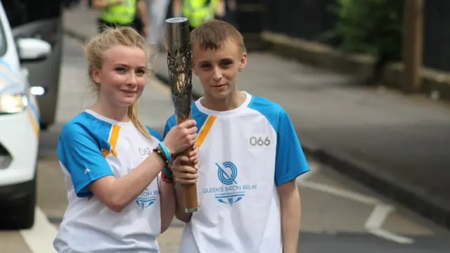 Two baton bearers pose with baton