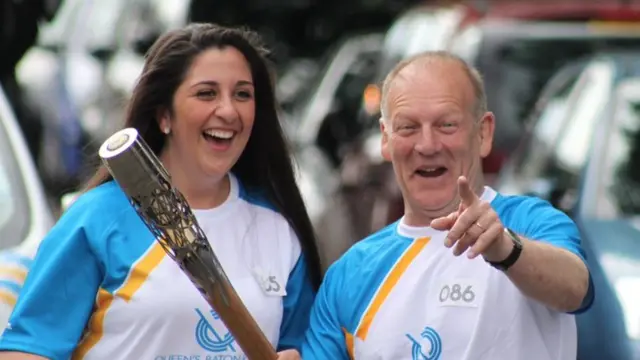 Baton bearer points at camera