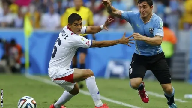 Costa Rica's Cristian Gamboa and Uruguay's Cristian Rodriguez fight for the ball