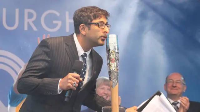 Sanjeev Kohli kisses the Queen's baton