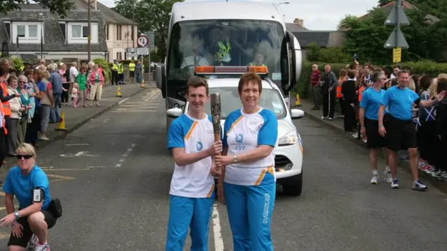 Baton bearers Susan Maitland and Kieran Fergusson were cheered outside Penicuik High School.