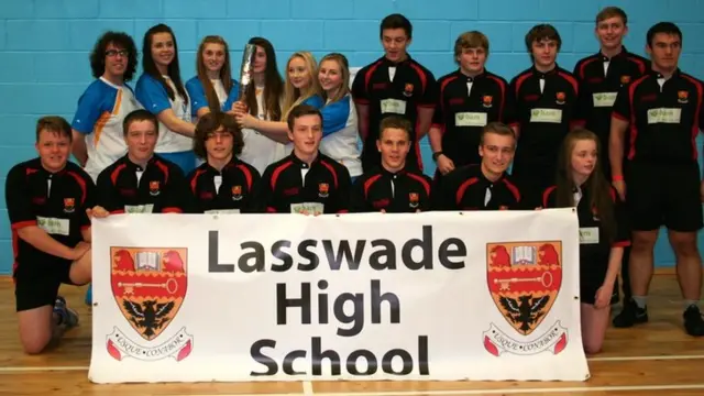 School student in group photo, holding banner saying "Lasswade High School".