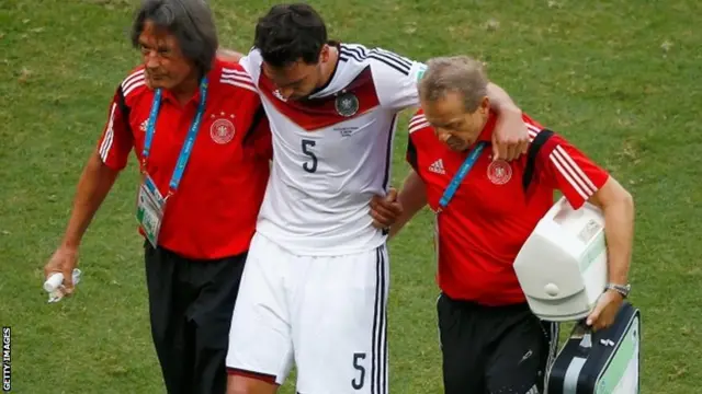 An injured Mats Hummels of Germany is helped off the field