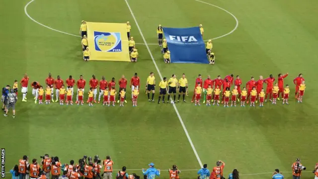 Ghana's and the US players listen to their national anthems