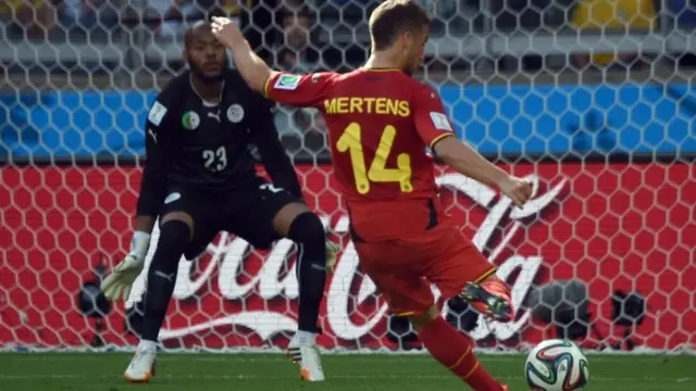 Dries Mertens shoots to score against Algeria's goalkeeper Rais Mbohli