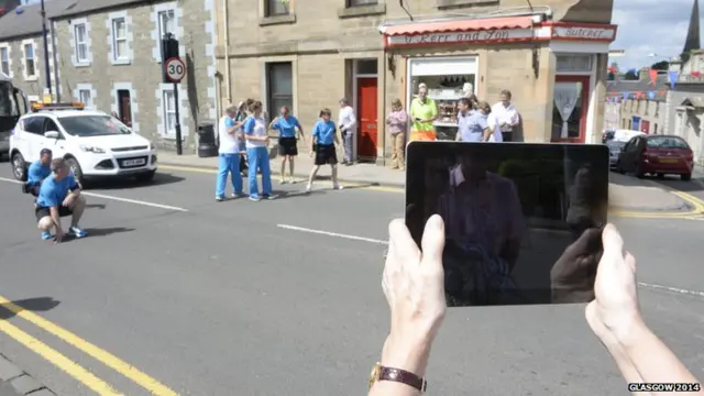 Woman takes a picture of the baton relay