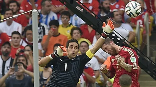 Chile keeper Claudio Bravo punches the ball away from Spain's Sergio Ramos