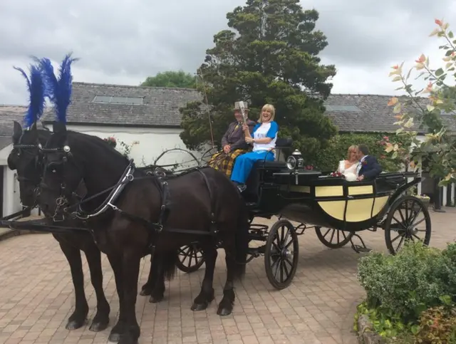 Ashley Jensen in a horse and cart with the baton