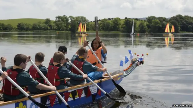 Kirsten Gair carries the Glasgow 2014 Queen's Baton on a canoe at Carlingwark Outdoor Centre in Dumfries & Galloway.