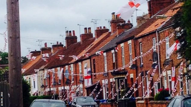 Houses on a street display England flags