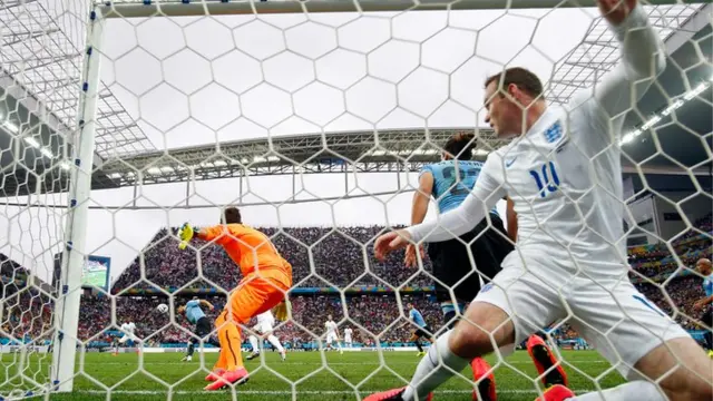 Wayne Rooney falls in the net after his header